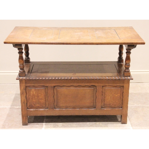 769 - An early 20th century medium oak monks bench, the three panel sliding back rest raised upon four bal... 