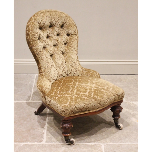 775 - A Victorian walnut and upholstered nursing chair, in foliate damask fabric, the button back above a ... 