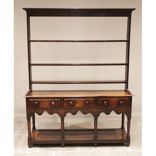 786 - An early 19th century oak Welsh dresser, the open plate rack with a moulded cornice over three shelv... 