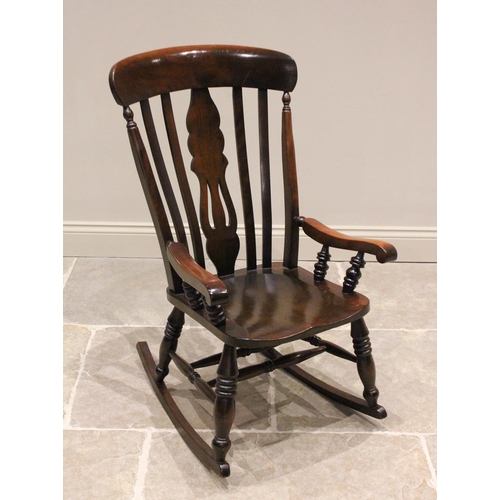 788 - A stained beech wood rocking chair, 20th century, with a lath back and pierced central splat, the tu... 