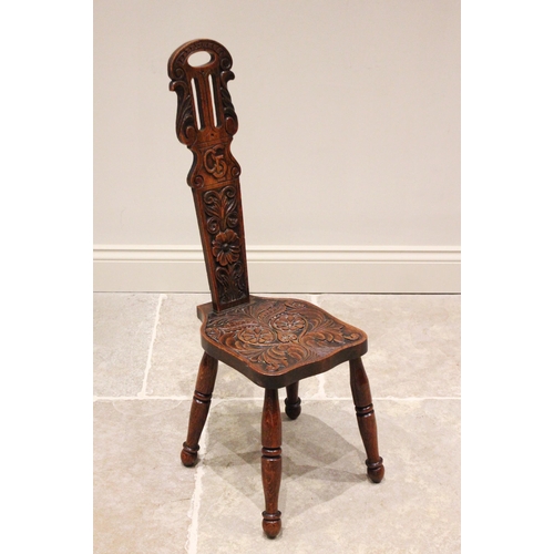 790 - A late Victorian carved oak spinning chair, the carved and pierced high back rest centred with carve... 