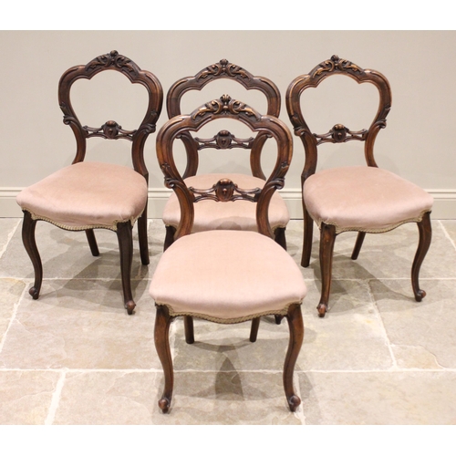 796 - A set of four Victorian walnut balloon back dining chairs, each with a 'C' scroll and foliate carved... 