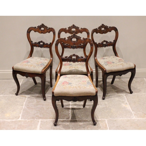 798 - A set of four Victorian walnut dining chairs, each with a leafy crest over a 'C' scroll framed apert... 