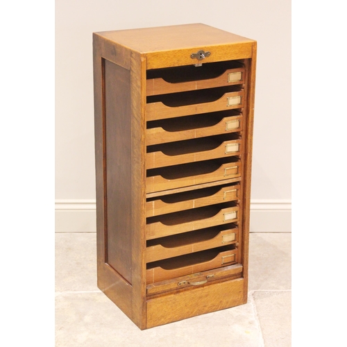 807 - An early 20th century tambour front oak filing cabinet, the tambour drop front opening to nine slidi... 