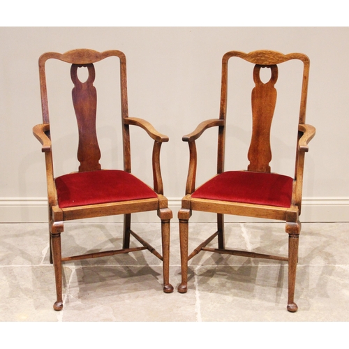 808 - A set of four early 20th century oak dining chairs, each with a carved crest rail above a wavy lath ... 