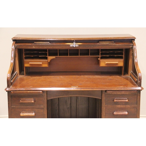 809 - An early 20th century oak roll top desk, the tambour front opening to an arrangement of small drawer... 