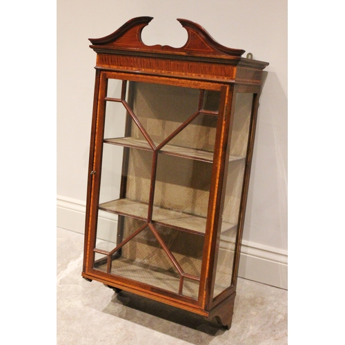 818 - An Edwardian Sheraton revival wall hanging mahogany display cabinet, the broken architectural pedime... 