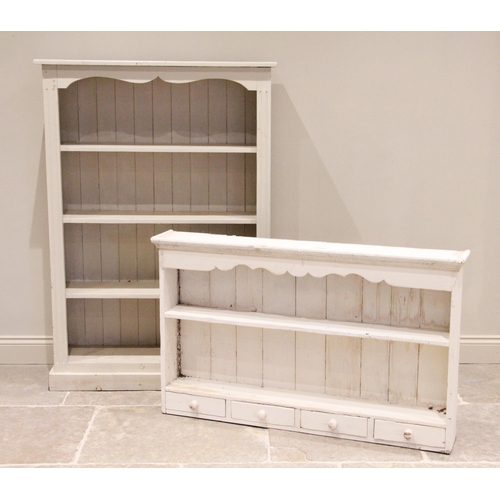 823 - A painted pine open bookcase, 20th century, the fluted uprights united by a shaped frieze over three... 