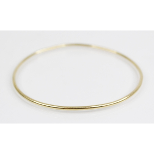 93 - An 18ct gold bangle, marks for Sheffield 2000, of plain polished circular form, 6.8cm wide, weight 9... 