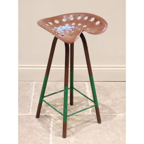 630 - An implement-seat stool, the shaped and drilled cast metal seat raised upon four tubular section leg... 