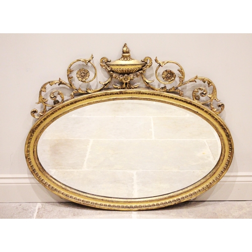 678 - An Adams style gilt wood and gesso oval wall mirror, 19th century, the frame surmounted with an urn ... 