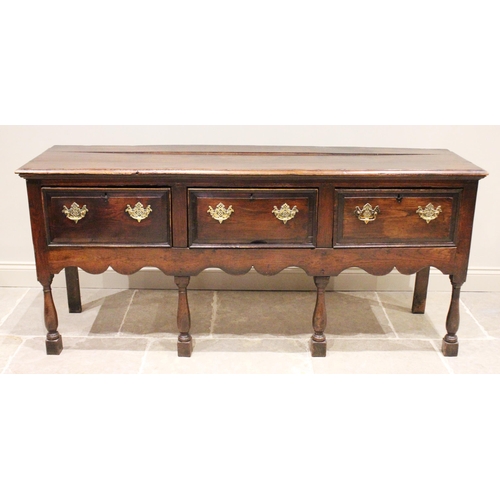 706 - An early 18th century oak dresser base, the three plank moulded top above three lip moulded frieze d... 