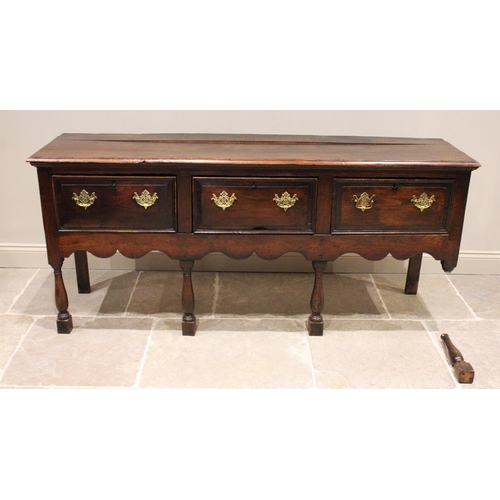 706 - An early 18th century oak dresser base, the three plank moulded top above three lip moulded frieze d... 