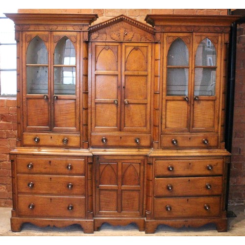 783 - A mid 19th century inverted breakfront oak housekeepers cupboard, the central architectural pediment... 