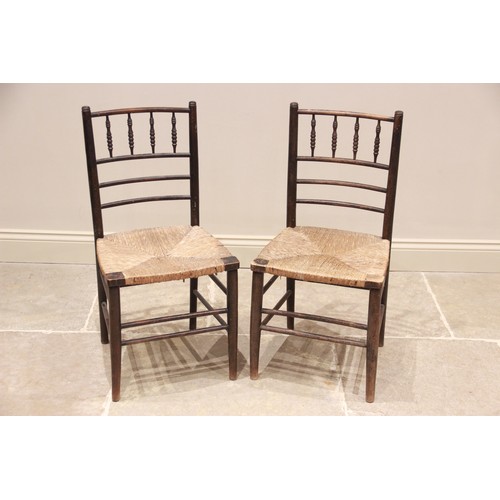 780 - A pair of Arts and Crafts Morris type Sussex chairs, with a spindle and rail backs above an envelope... 