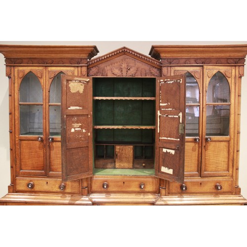 783 - A mid 19th century inverted breakfront oak housekeepers cupboard, the central architectural pediment... 