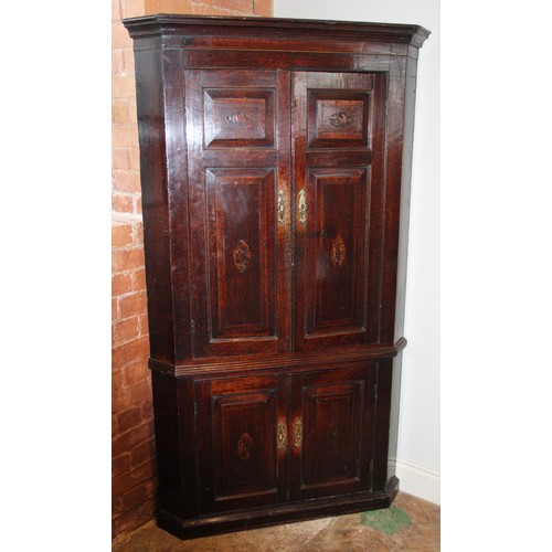 732 - A George III oak and mahogany cross banded freestanding corner cupboard, the moulded cornice above a... 