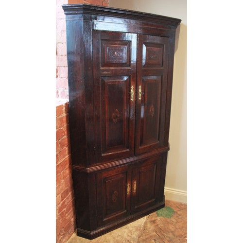 732 - A George III oak and mahogany cross banded freestanding corner cupboard, the moulded cornice above a... 