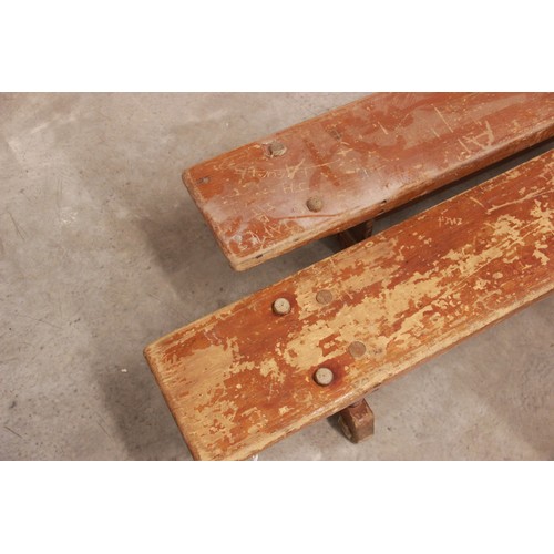 822 - A pair of mid century stained wooden school gym benches, each raised on three trestle type supports,... 