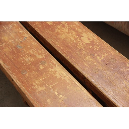 822 - A pair of mid century stained wooden school gym benches, each raised on three trestle type supports,... 