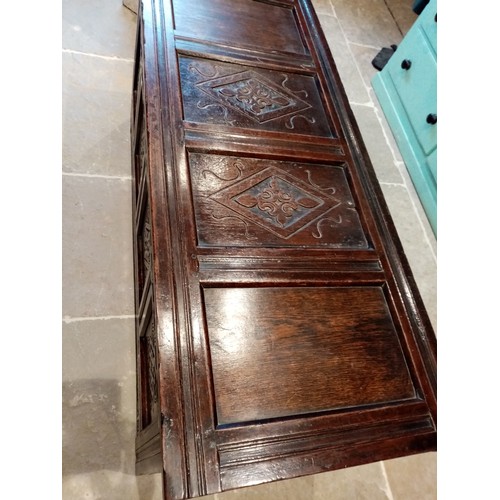 714 - A large 18th century carved oak coffer, with a four panel hinged cover, the two central panels carve... 