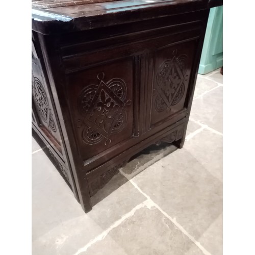 714 - A large 18th century carved oak coffer, with a four panel hinged cover, the two central panels carve... 