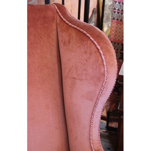 729 - A George III wing back fireside armchair, later re-covered in pink velour with applied rope detail, ... 