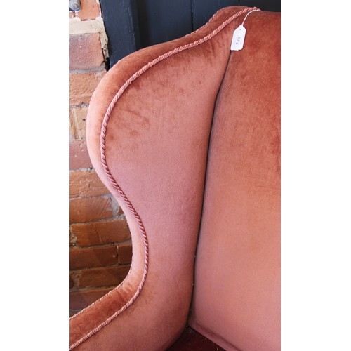 729 - A George III wing back fireside armchair, later re-covered in pink velour with applied rope detail, ... 