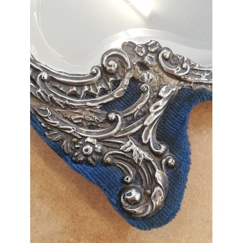 44 - An Edwardian silver mounted mirror, Henry Matthews, Birmingham 1902, the shaped mirror with embossed... 