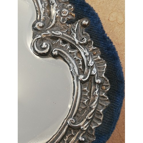 44 - An Edwardian silver mounted mirror, Henry Matthews, Birmingham 1902, the shaped mirror with embossed... 
