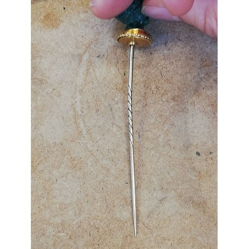 116 - A malachite stick pin, carved in the classical style as a female head with waved hair and a crown of... 