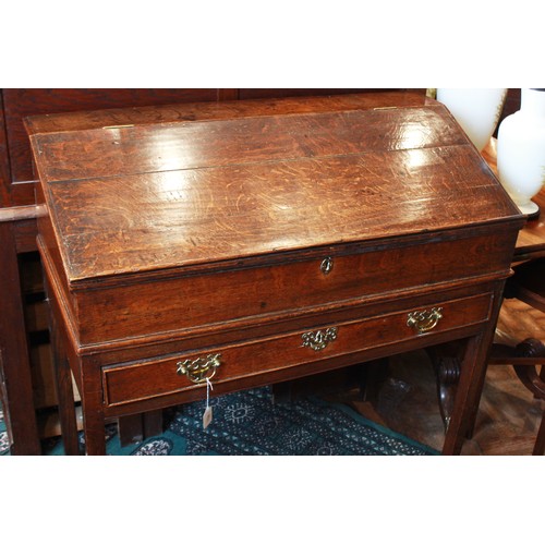 739 - A George III oak clerk’s desk, the hinged slope opening to two small drawers and a pigeon hole, abov... 