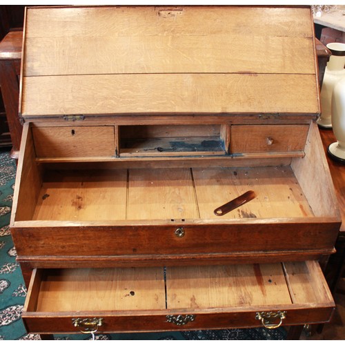 739 - A George III oak clerk’s desk, the hinged slope opening to two small drawers and a pigeon hole, abov... 