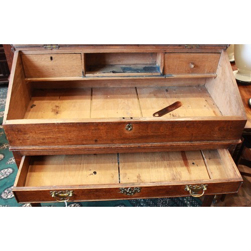 739 - A George III oak clerk’s desk, the hinged slope opening to two small drawers and a pigeon hole, abov... 