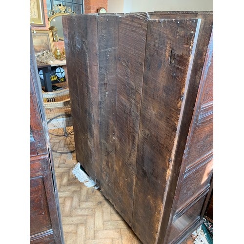 718 - An 18th century oak panelled hall/livery cupboard, formed as a central cupboard door below two drawe... 