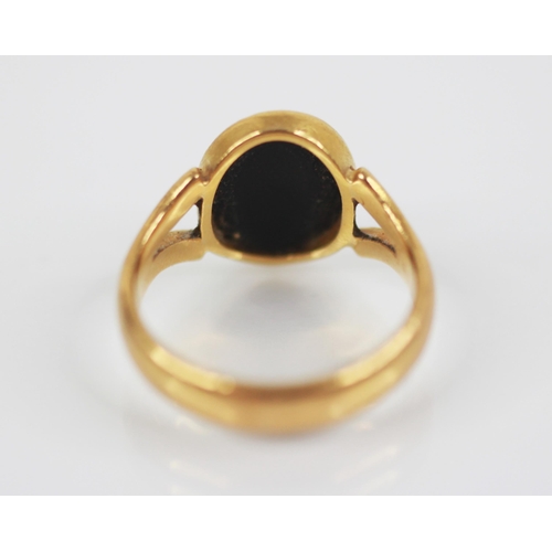 107 - A 22ct gold onyx set ring, the plain polished oval panel measuring 11mm x 9mm, bezel set to split sh... 