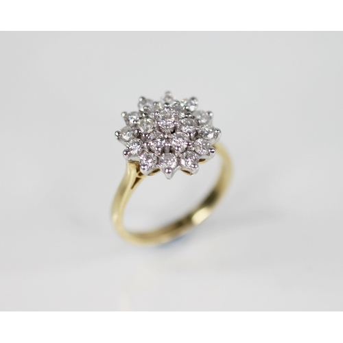 134 - A diamond floral cluster ring, designed as a tiered cluster of nineteen round brilliant cut diamonds... 