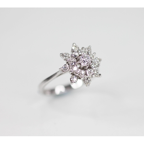 135 - A diamond floral cluster ring, comprising a central round brilliant cut diamond weighing 0.10 - 0.15... 