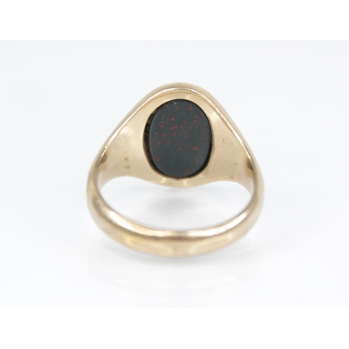 139 - A 9ct gold bloodstone set signet ring, the oval plain polished bloodstone matrix measuring 13.2mm x ... 