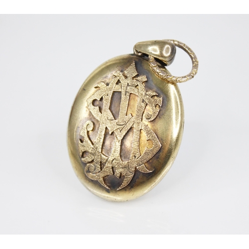 151 - A Victorian locket pendant, the unmarked gold coloured pendant of oval form, the cover with applied ... 