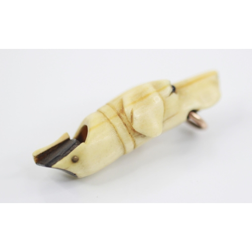 171 - A Victorian carved ivory dog whistle, modelled as a hound with glass eyes and gold coloured ring to ... 