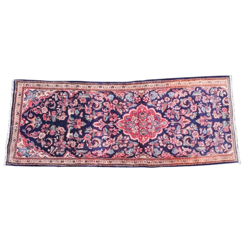 483 - An Iranian blue ground floor runner, the central floral medallion enclosed by trailing foliate motif... 