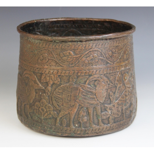 593 - An Indian copper vessel, 19th century, of tapering form, the sides extensively decorated with a cont... 