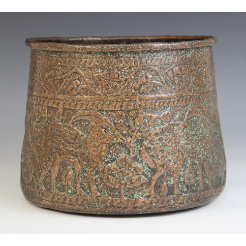 593 - An Indian copper vessel, 19th century, of tapering form, the sides extensively decorated with a cont... 