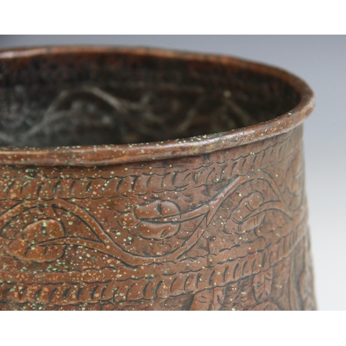 593 - An Indian copper vessel, 19th century, of tapering form, the sides extensively decorated with a cont... 