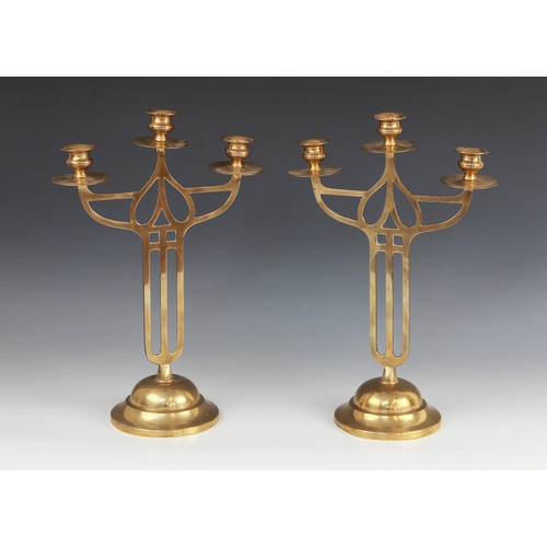 605 - A pair of early 20th century brass Art Nouveau candelabra in the Mackintosh style, each with three b... 