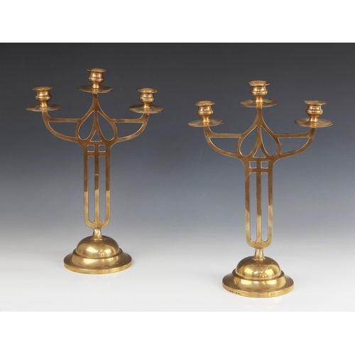 605 - A pair of early 20th century brass Art Nouveau candelabra in the Mackintosh style, each with three b... 