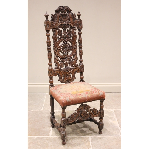 735 - A carved walnut Carolean style hall chair, 19th century, the carved foliate and 'C' scroll high back... 