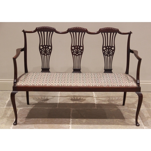 748 - An Edwardian mahogany salon sofa, the undulating top rail over three pierced splats and a padded sea... 