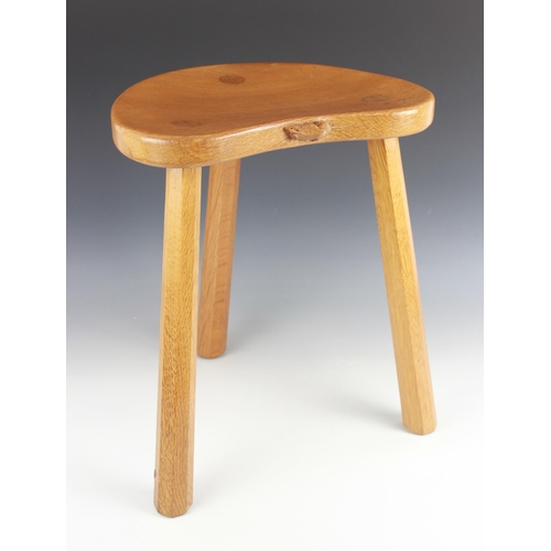 765 - A Robert 'Mouseman' Thompson of Kilburn golden oak milking stool, mid 20th century, the kidney shape... 